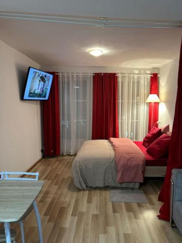 Cette chambre comprend un lit avec des rideaux rouges et une télévision. dans l'établissement Appart Paris 10 eme, à Paris
