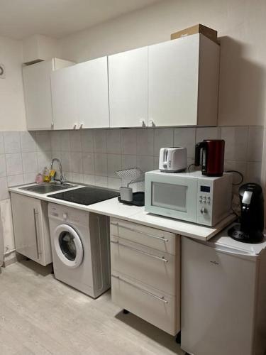 une cuisine avec un micro-ondes et un lave-linge dans l'établissement Appart Paris 10 eme, à Paris
