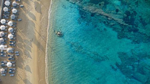una vista aerea su una spiaggia con ombrelloni e sull'oceano di Liana Beach Hotel & Spa ad Agios Prokopios