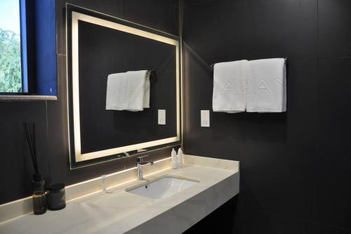 a bathroom with a sink and a mirror and towels at The Corner, Luxury One-Bedroom in Ras al Khaimah