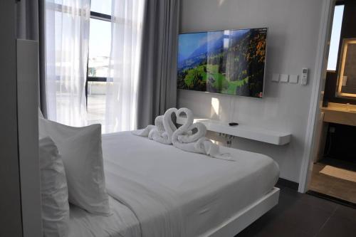 a bedroom with a white bed with towels on it at The Corner, Luxury One-Bedroom in Ras al Khaimah