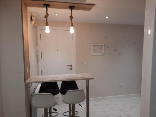 a kitchen with a table and four stools at Villa- Belen in Santo Domingo de la Calzada