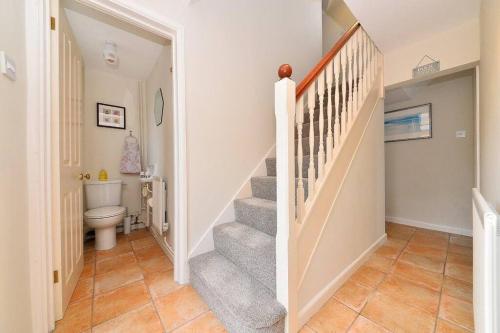 een hal met een trap en een toilet in een huis bij Quaint Victorian Coach House in village location in Great Alne