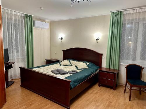 a bedroom with a bed with green curtains and a chair at Duets in Daugavpils