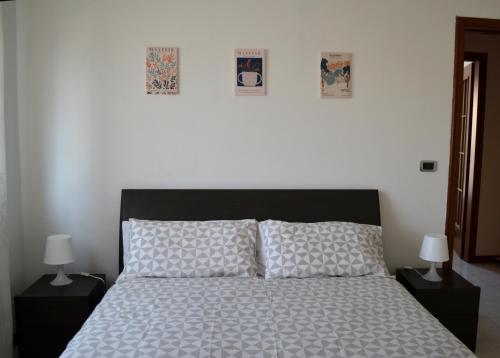 una camera con un letto con due comodini e due lampade di la Dolce Vita - Appartamento con parcheggio privato vicino al centro e all'ospedale ad Asti