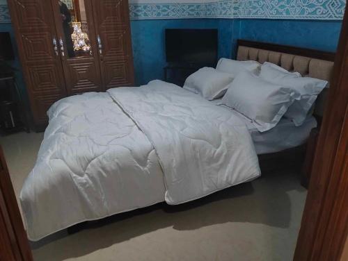 ein großes weißes Bett mit weißer Bettwäsche und Kissen in der Unterkunft La rose des sables 