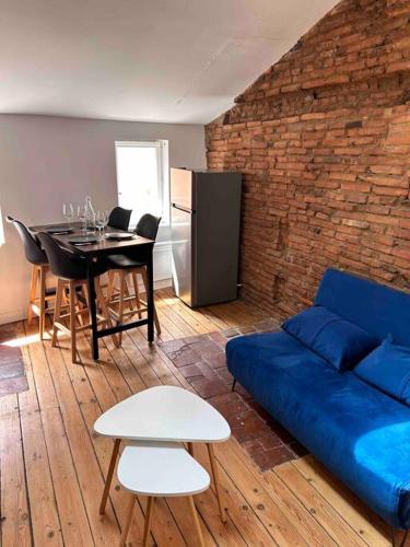 un salon avec un canapé bleu et une table dans l'établissement Appartement - Carmes, à Toulouse