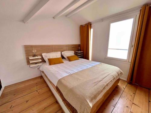 um quarto com uma cama grande e uma janela em Appartement - Carmes em Toulouse