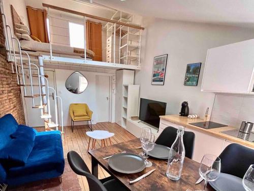 uma sala de estar com uma mesa de jantar e uma cama alta em Appartement - Carmes em Toulouse