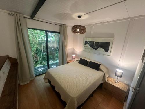 a bedroom with a bed and a large window at Posada Guasu in Punta del Este