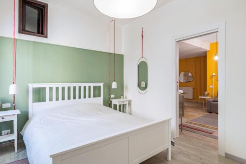 una camera da letto con un letto bianco e una parete con accento verde di Casa San Faustino - Brescia CityCenter - by HOST4U a Brescia