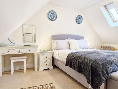 a bedroom with a bed and a vanity and a mirror at Pears Grove - Southbourne in Emsworth