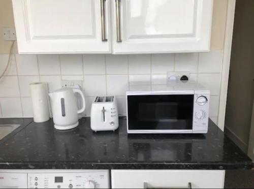 encimera de cocina con microondas y electrodomésticos en Ac lounge 115 1-Bed Apartment in Rochford, en Rochford