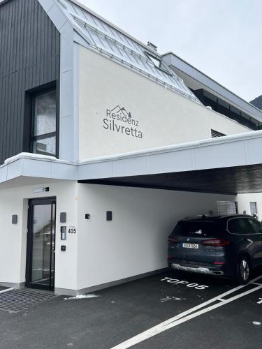 a car parked in a parking lot in front of a building at Das luxuriöse Chalet-Apartment in der Residenz Silvretta - Inklusive Silvretta Card Premium in See