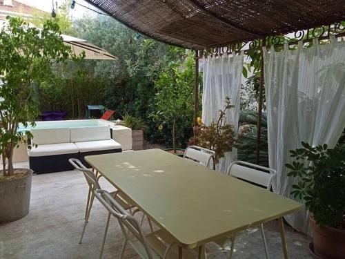 un patio avec une table et des chaises et une piscine dans l'établissement Maison centre-ville, à La Valette-du-Var