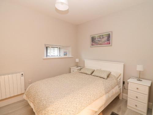 a bedroom with a bed and two night stands at Oak Tree Cottage in Enniscorthy