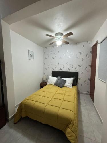 a bedroom with a yellow bed with a ceiling fan at Hermosa Hab,Internet,Centrico, Wi-Fi in Xalapa