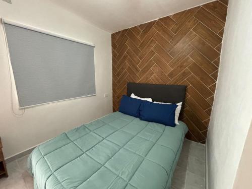 Dormitorio pequeño con cama con almohadas azules en IncreIble Hab,Centrica,Internet,Parking, en Xalapa