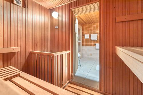 a bathroom with wood paneled walls and a walk in shower at Haus Erna am Deister Apartment in Barsinghausen