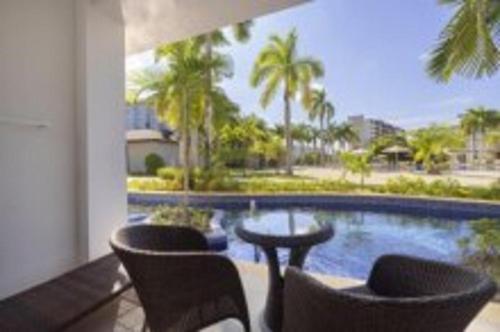 a balcony with two chairs and a swimming pool at Royalton Hideaway Blue Waters, An Autograph Collection All-Inclusive Resort - Adults Only in Falmouth