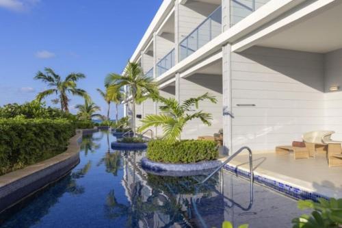 a swimming pool in a building with palm trees at Royalton Hideaway Blue Waters, An Autograph Collection All-Inclusive Resort - Adults Only in Falmouth