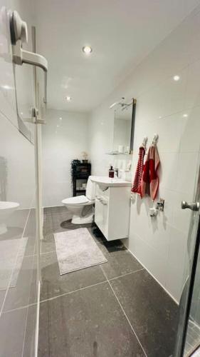 a white bathroom with a sink and a toilet at Newly built amazing apartment in Järfälla