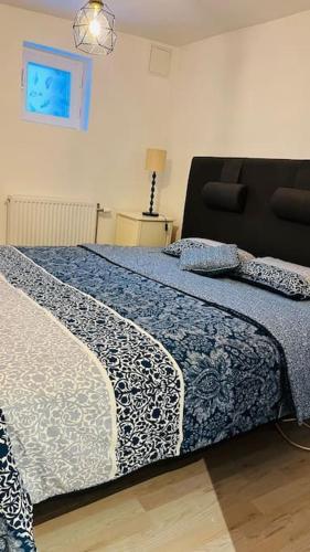 a bedroom with a bed with a blue comforter at Newly built amazing apartment in Järfälla