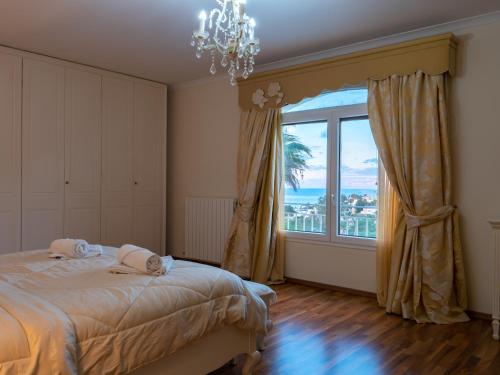 sypialnia z łóżkiem i dużym oknem w obiekcie Villa Alexandra - Sunset Sea Views, Heated Jacuzzi, Sauna and Gym w mieście Mellieħa