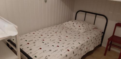 a small bedroom with a bed with flowers on it at Les Ecrins in Les Mages