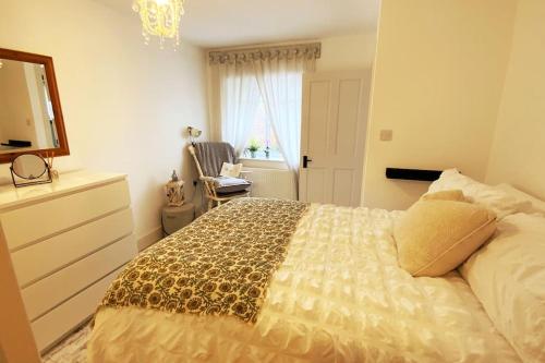 a bedroom with a bed with a dresser and a mirror at Beautiful 1 bed annex, near beach and shops in Iford