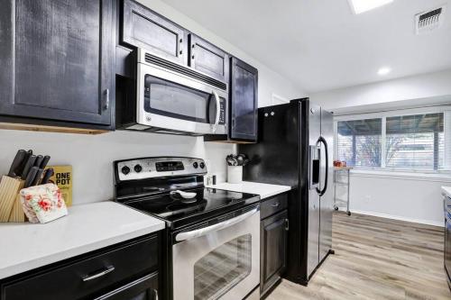 a kitchen with a stove and a microwave at Centrally Located Little Gem in San Antonio