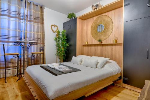 a bedroom with a large bed with a wooden headboard at Agréable studio proche Paris et Porte de Versailles in Malakoff