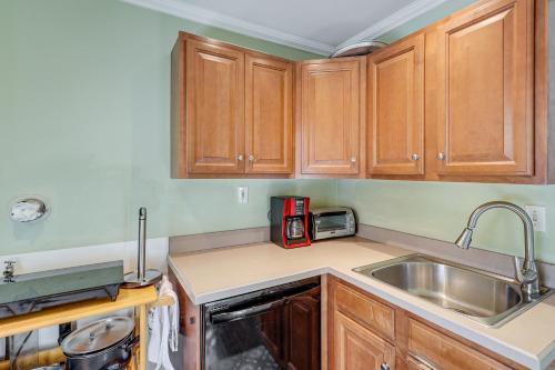 a kitchen with wooden cabinets and a sink at Charming Connecticut Retreat Near Museums and Hiking in Waterbury