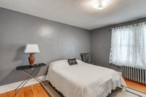 a bedroom with a bed and a lamp and a window at Charming Connecticut Retreat Near Museums and Hiking in Waterbury