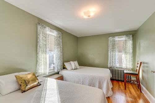 1 dormitorio con 2 camas y 2 ventanas en Charming Connecticut Retreat Near Museums and Hiking en Waterbury