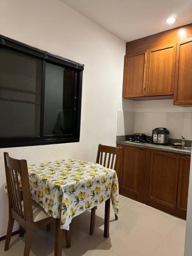 een keuken met een tafel en twee stoelen met een tafelkleed erop bij Apartment in Ban Mae Nam