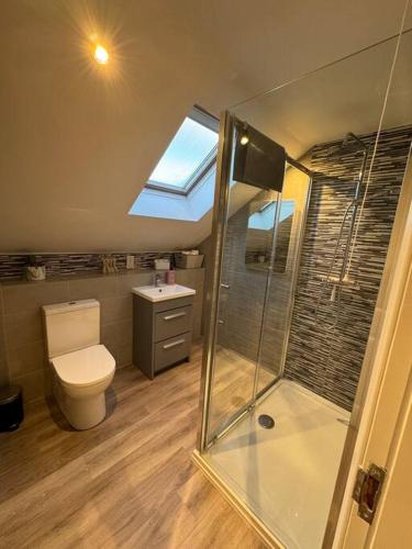 a bathroom with a toilet and a glass shower at Beautiful two bed home in Marsh in Lindley