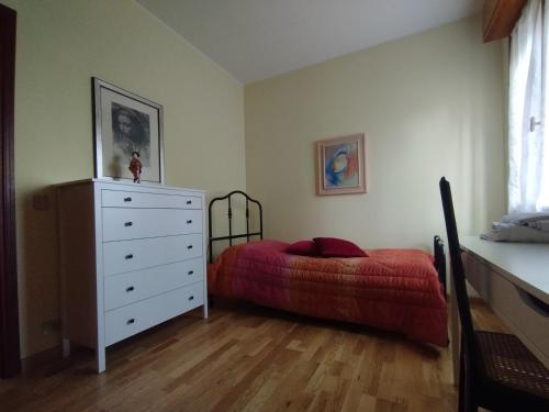 een slaapkamer met een bed en een dressoir met een rode deken bij Civico 51Appartamento a Sassuolo in Sassuolo