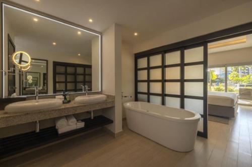 a bathroom with two sinks and a bath tub at Royalton Hideaway Blue Waters, An Autograph Collection All-Inclusive Resort - Adults Only in Falmouth