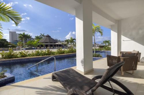 a patio with a chair and a swimming pool at Royalton Hideaway Blue Waters, An Autograph Collection All-Inclusive Resort - Adults Only in Falmouth