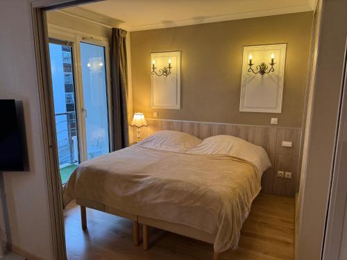 a bedroom with a bed with two pictures on the wall at ALTAMIRA (Paris Expo - Porte de Versailles) in Issy-les-Moulineaux