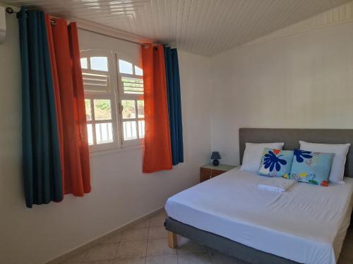 ein Schlafzimmer mit einem Bett und einem Fenster in der Unterkunft Hébergements La Favorite in Le Lamentin