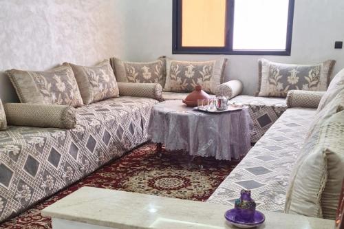 a living room with a couch and a table at Rooms in shared apartment close to CMN-Airport in Dah Hammou Ben Cheïkh