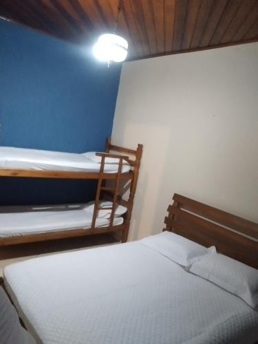 a bedroom with two bunk beds and a blue wall at Recanto do Bem-Te-Vi in Olímpia