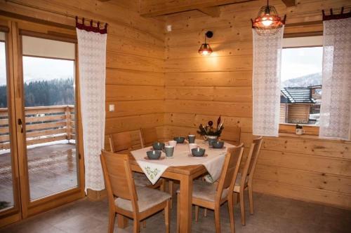 a dining room with a table and chairs in a cabin at Domek na Zawojskim Przysłopiu in Zawoja