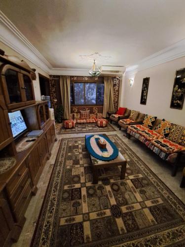 sala de estar con sofá y mesa en Panorama apartment with a charming view of Cairo International Airport All the apt for you with free airport pick up or drop off limousine شقة بانوراما بإطلالة ساحرة على مطار القاهرة الدولي en El Cairo