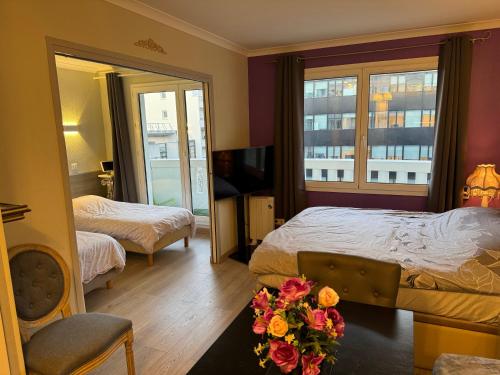 a hotel room with two beds and a television at ALTAMIRA (Paris Expo - Porte de Versailles) in Issy-les-Moulineaux