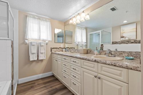 a bathroom with two sinks and a shower at Oceanwalk 1-401 in New Smyrna Beach