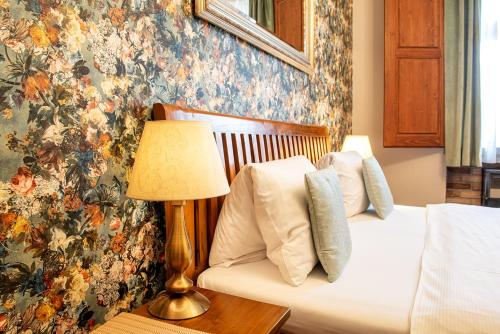 a bedroom with a bed and a table with a lamp at Residence Hattrick in Prague