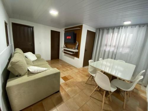 sala de estar con sofá y mesa en BS01- Casa Aconchegante| Equipada| Churrasqueira|, en Balneário Barra do Sul